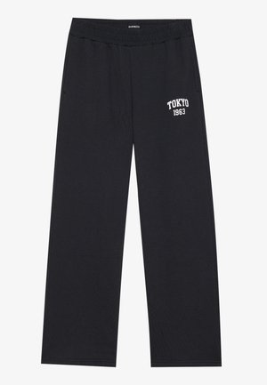 Μαύρες βαμβακερές φόρμες με ελαστική μέση, πλαϊνές τσέπες και λευκή εκτύπωση "TOKYO 1963" στον αριστερό μηρό.