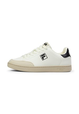 Baskets de sport blanches avec une tige en cuir lisse, semelle beige et accents noirs ; elles comportent des lacets plats et un logo sur le côté et la languette.