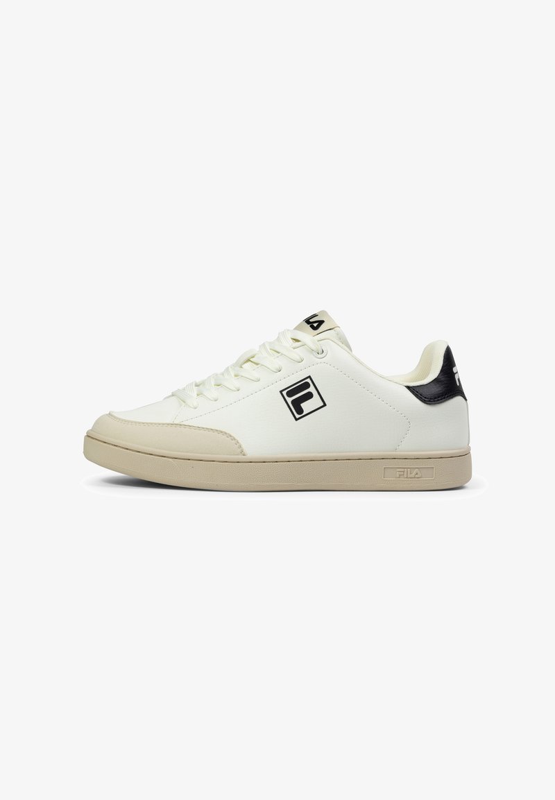 Baskets de sport blanches avec une tige en cuir lisse, semelle beige et accents noirs ; elles comportent des lacets plats et un logo sur le côté et la languette.