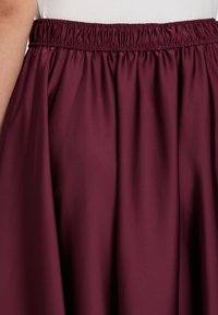 Bordeaux Midi-Rock mit elastischem Bund, aus einem glatten, weichen Stoff gefertigt, mit einem fließenden Design und subtiler Satinoptik.