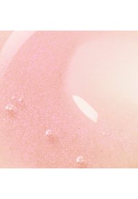 Glänzendes rosa Gel mit funkelnden Partikeln und kleinen Luftblasen, in Nahaufnahme gezeigt.