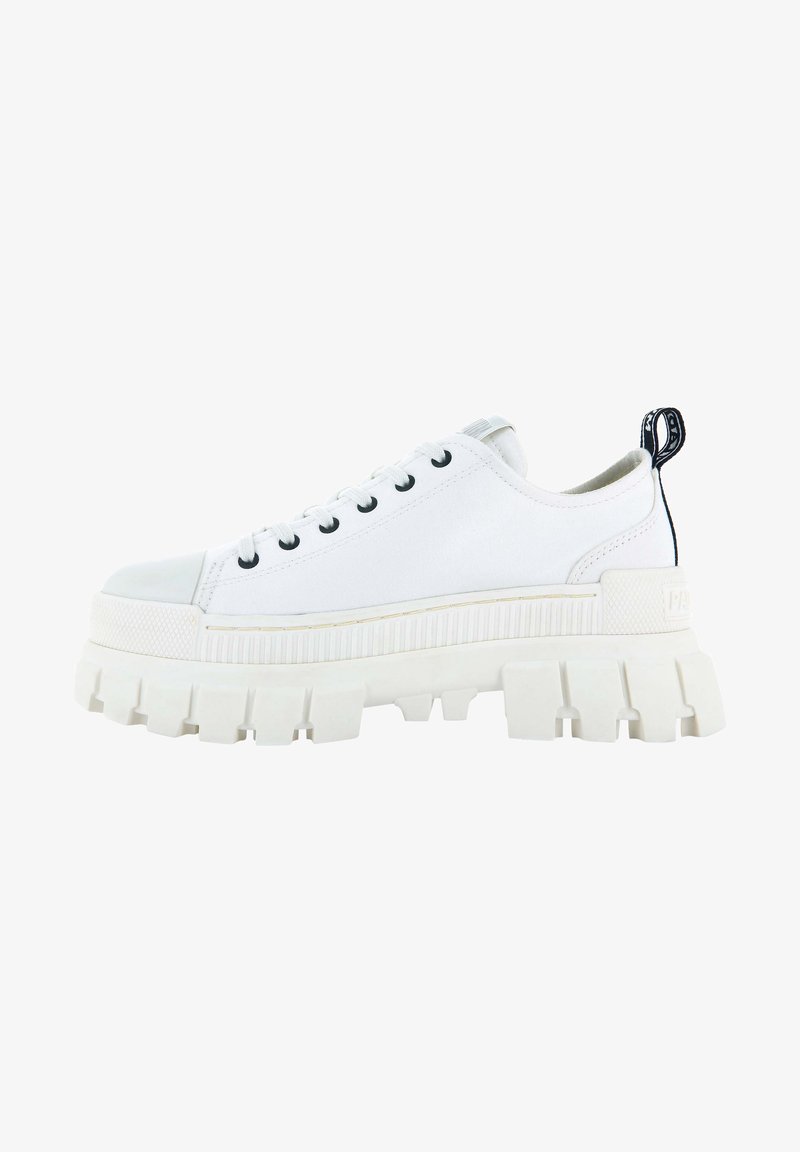 Baskets basses blanches avec semelle crantée épaisse, œillets noirs, lacets blancs et languette noire au talon.