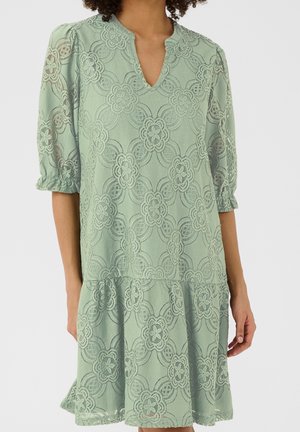 Light green lace dress with floral pattern, three-quarter puff sleeves, elastic cuffs, and a small V-neckline.
