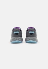 Zapatillas deportivas grises y azules con una parte superior texturizada, detalles de malla y una suela acolchada. Presenta acentos morados en el collar.