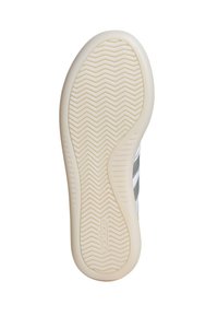 Semelle de chaussure avec un design en caoutchouc texturé, présentant un motif en chevrons et un bord lisse de couleur crème. Logo de la marque en relief.