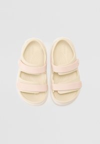 Sandalias de color rosa claro y beige con dos correas ajustables, plantilla texturizada y punta redondeada, que presentan un destacado detalle del logo.