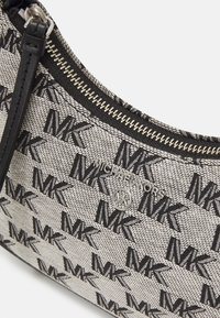 Borsa a spalla in tessuto con texture che presenta un motivo ripetuto del logo "MK" nero, zip in argento e una tracolla in pelle nera.