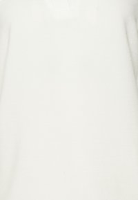 Weißes Langarmshirt aus weichem Stoff, mit einem V-Ausschnitt und einer glatten Textur sowie minimalen Details.