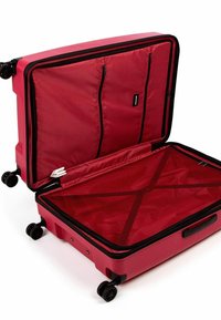 Červený tvrdý kufr s dvěma zipovými vnitřními kapsami, síťovými popruhy a čtyřmi koly pro snadnější pohyb. Otevřený design ukazuje prostorný vnitřek.