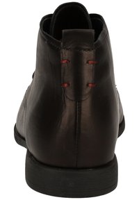 Schwarze Lederstiefelette mit glatter Oberfläche, runder Zehenform, minimaler Naht und roten Akzent-Schnürsenkeln hinten. Schwarze Gummisohle.