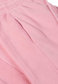 Roze stof met een gladde textuur, subtiele diagonale weving en een gathering detail bij de tailleband, die een ontspannen pasvorm laat zien.