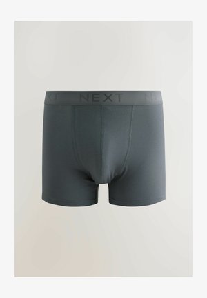Boxers gris foncé en matériau doux, avec une large ceinture portant le mot "NEXT" en noir. Texture lisse sans motifs visibles.