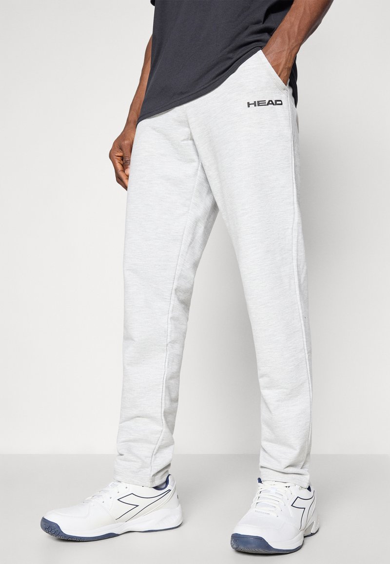 Pantalones de chándal gris claro con bolsillos laterales, cintura con cordón, diseño de pierna recta y un logo negro de 'HEAD' en el lado izquierdo.