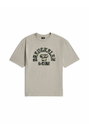 Beżowy T-shirt z krótkim rękawem i okrągłym dekoltem, z tekstem "BREUCKELEN" i "G-STAR" w nadruku moro na przodzie.
