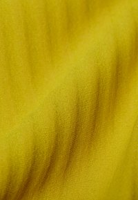 Tessuto giallo brillante con una texture liscia, caratterizzato da sottili strisce verticali e una superficie morbida, leggermente riflettente.