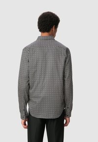 Langsleeve overhemd in zwart en wit met een geometrisch patroon, knopenkraag en rechte zoom. Gemaakt van een zachte stof.