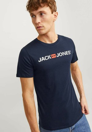 Navy blue cotton t-shirt featuring a white logo print "JACK & JONES" with a red accent. Short sleeves, round neckline, smooth texture.
