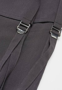 Deux sangles en tissu noir avec des attaches à boucle en métal argenté sur un fond blanc uni.