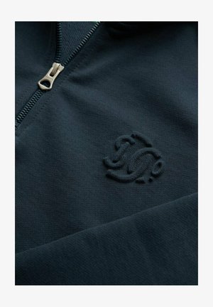 Marineblå zip-up sweatshirt lavet af tekstureret stof med et subtilt præget logo på venstre bryst og en metal lynlås.