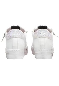 Sneakers bianchi con tomaia in pelle liscia, punta rotonda e un accento luccicante di glitter sul tallone. Suola in gomma e design con lacci.