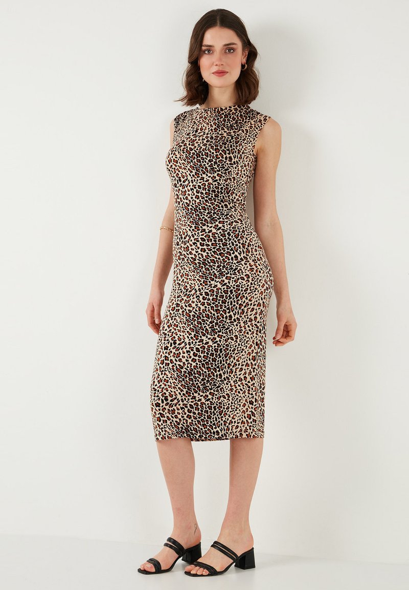 Leopard print fitted dress with a round neck, sleeveless design, and knee-length hem. Smooth fabric and subtle sheen. Black strappy sandals.