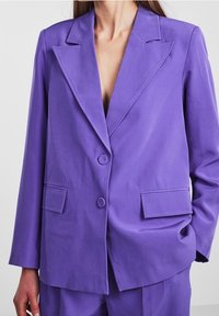Fialový blazer, strukturovaný design, klopy s výstřihem, dvě přední kapsy, uzávěr na jeden knoflík, hladká textura, přizpůsobený střih.
