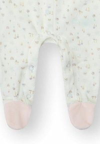 Pijamas con pies de color claro hechas de tela suave, con un patrón de pequeñas flores y arcoíris; puños de pies rosas y cierres de broche.