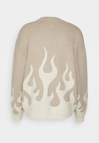 Beżowy sweter dzianinowy z kremowym wzorem płomieni na dolnej części. Okrągły dekolt i luźny krój. Teksturowany materiał z prążkowanym wykończeniem u dołu i przy rękawach.