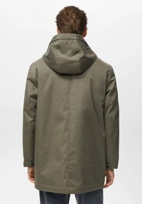 Chaqueta impermeable de color verde oliva, diseño de longitud media, con capucha fija, detalles de botones de presión en las mangas, textura suave, adecuada para ropa de exterior.