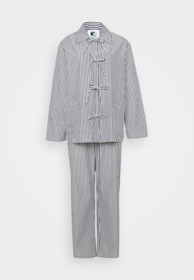Striped two-piece outfit consisting of a jacket with toggle closures and matching trousers. Colors are primarily white and navy blue.