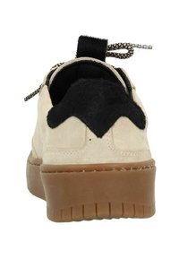 Basket beige en suède avec des accents en fourrure noire, bout rond, semelle en caoutchouc texturée et système de laçage. Comprend une languette au talon.