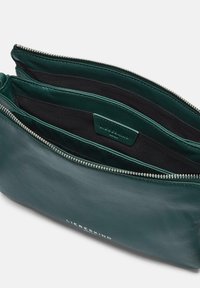 Zielony skórzany woreczek o gładkiej fakturze, zamykany na zamek błyskawiczny, z wieloma przegródkami. Wnętrze wyłożone czarną tkaniną i oznaczone metką marki.