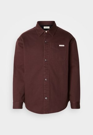 Camicia bordeaux a manica lunga in cotone, con colletto, taschino sul petto e un'etichetta con logo discreta sulla tasca.
