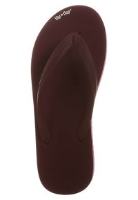 Üks tumepruun plätud sandal tekstuursete rihmadega ja "flip*flop" logo varvaste piirkonnas valge taustal.