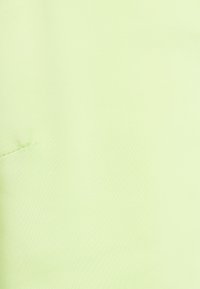 Tecido verde claro com uma textura suave, apresentando um brilho subtil e uma aparência simples e uniforme. Sem padrões visíveis ou hardware.