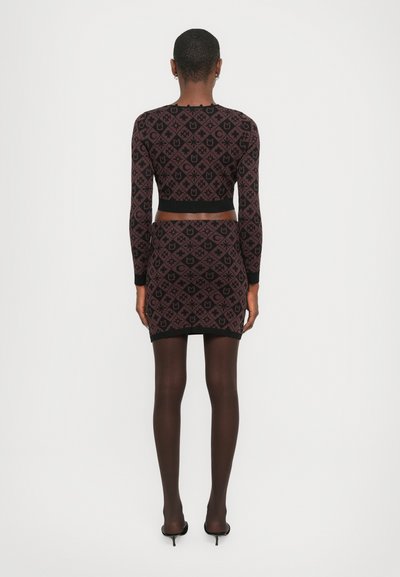 Knit two-piece outfit in burgundy and black, featuring geometric patterns. Long-sleeved top and fitted mini skirt, with ribbed accents.