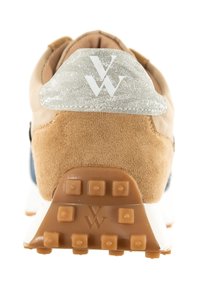 Zapatilla de ante y malla en tono marrón con una etiqueta en el talón en gris metálico que presenta un logotipo blanco, suela de goma texturizada y acentos en azul oscuro.