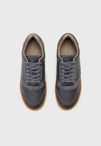 Dunkelblaue Ledersneaker mit grauen Wildlederakzenten, perforierten Details und grauen Schnürsenkeln. Gummisohle, abgerundete Spitze und gesticktes Design.