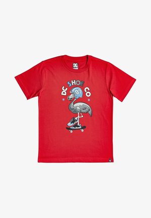 Czerwony T-shirt z grafiką ptaka w niebieskim kasku piłkarskim i trampkach, jadącego na deskorolce, nad którym znajduje się napis "DC SHOE CO".