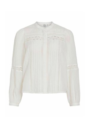 Blusa blanca con cuello mandarín, textura plisada, detalles de encaje y mangas largas abullonadas con puños abotonados. Hecha de tela ligera.