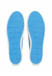 Modré gumové podrážky s texturovaným vzorem, s bílými okraji a reliéfním brandingem. Design obsahuje horizontální drážky pro lepší trakci.
