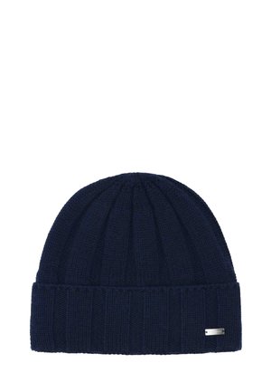 Dark blue ribbed knit beanie hat with a folded cuff and a small rectangular metal brand tag on the cuff's side.