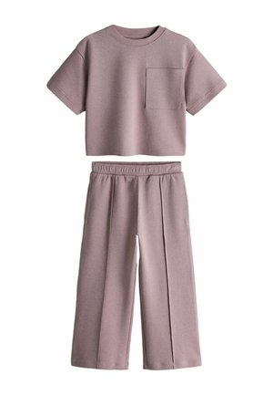 Súprava krátkeho crop topu svetlofialovej farby s krátkym rukávom a náprsným vreckom a zodpovedajúcich širokých nohavíc s vysokým pásom a elastickým pásom.