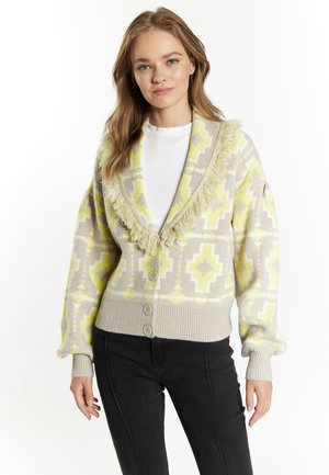 Grijze cardigan met een geel en wit geometrisch patroon, franjes aan de kraag en drie knopen aan de voorkant. Gebreide textuur en lange, losse mouwen.