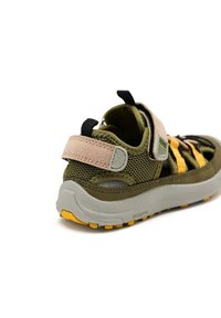 Sandali per bambini verdi e gialli con tomaia in rete, cinturino in Velcro e suola in gomma grigia. Presentano un design testurizzato e sezioni sagomate.
