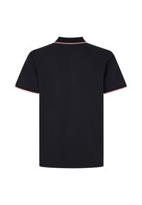 Czarna koszulka polo o klasycznym fasonie, z krótkimi rękawami oraz czerwonym i białym wykończeniem na kołnierzyku i brzegach rękawów. Miękka, bawełniana tekstura.