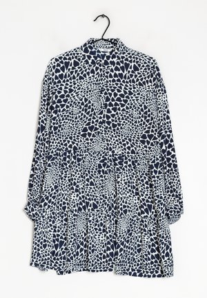 Chemise à manches longues avec un col, présentant un design abstrait de cœurs en bleu marine et blanc, fabriquée en tissu léger.
