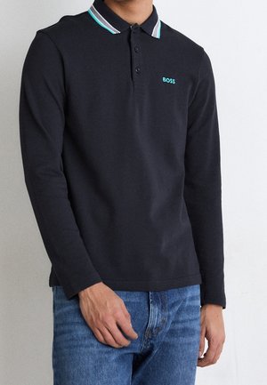 Polo noir à manches longues avec un col structuré comportant un léger accent rayé. Logo brodé "BOSS" en turquoise sur la poitrine.