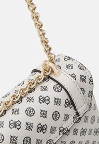 Borsa in pelle bianca con motivo logo nero, dotata di una tracolla in catena dorata e di una forma arrotondata. Include un dettaglio di chiusura decorativa.