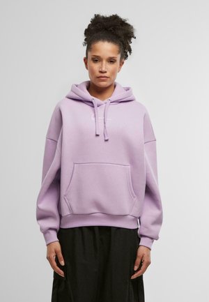 Lavender Hoodie mit einer Fronttasche, verstellbaren Kordeln und einem lockeren Schnitt. Mit einem einfachen weißen Logo auf der Brust.